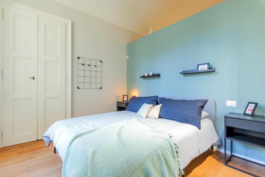 都灵Top Living Apartments - Torino Centro的一间卧室设有一张床和蓝色的墙壁