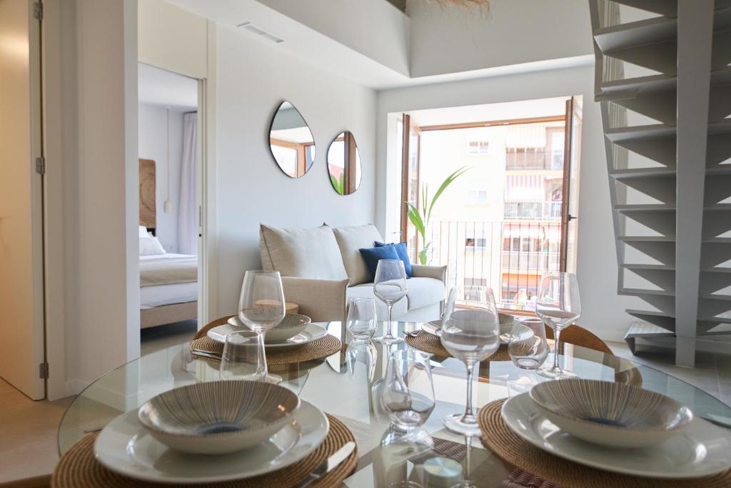 瓦伦西亚Slow Home Apartments的客厅配有玻璃桌和酒杯