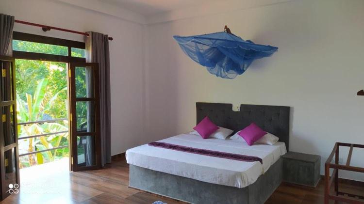 贝鲁沃勒Villa Sea Side Beruwala的卧室配有一张带粉红色枕头的大床