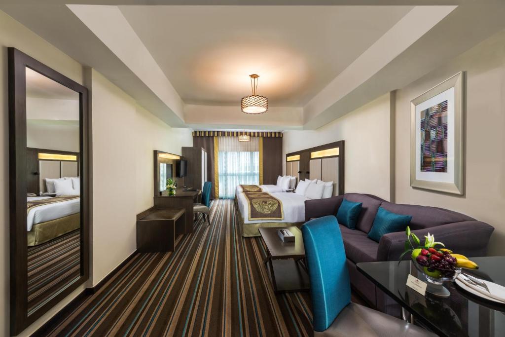 迪拜萨窝儿中央酒店公寓的酒店客房,配有床和沙发
