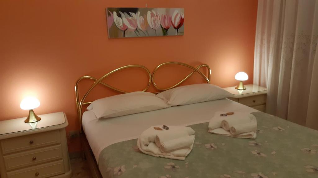 罗马Casa Giustino的一间卧室配有一张带两盏灯的床。