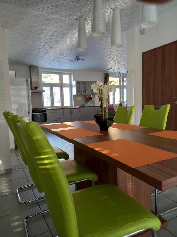米库洛夫Alegria Natur Apartments的厨房配有木桌和绿色椅子