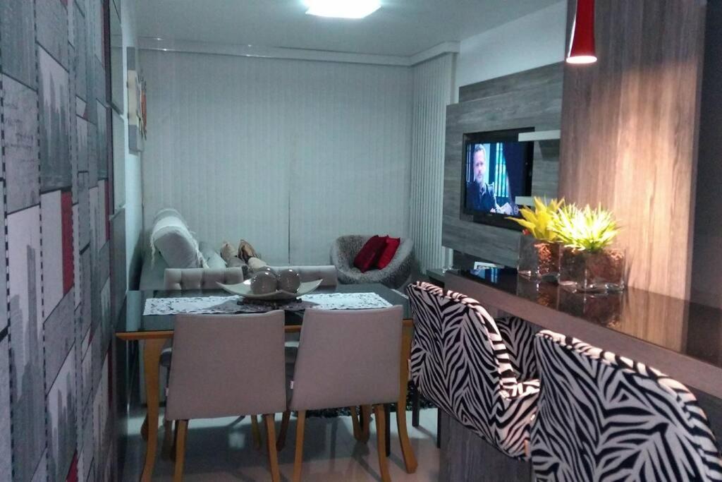 本图贡萨尔维斯Apartamento aconchegante em Bento Gonçalves, próximo ao vale dos vinhedos的一间带桌子和椅子的用餐室