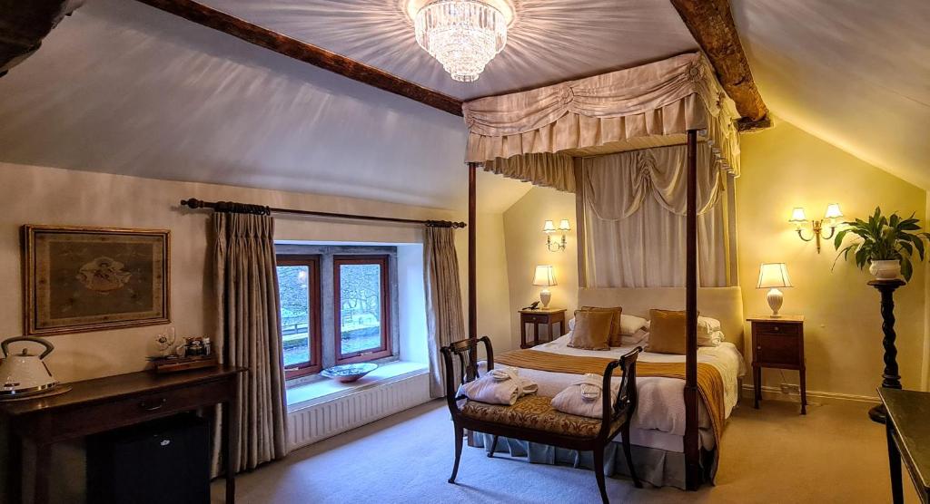 哈廷顿Biggin Hall Country House Hotel的一间卧室设有天蓬床和窗户。