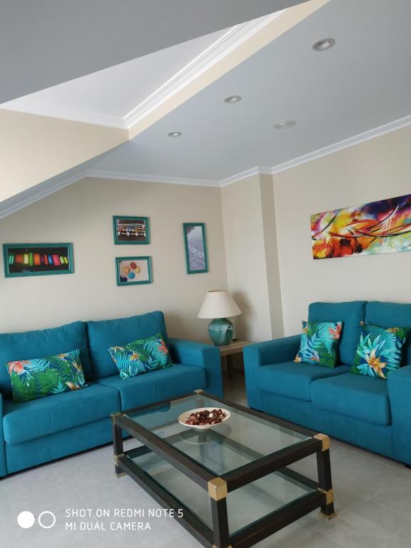 波多诺伏Anamari's的客厅配有蓝色的沙发和咖啡桌
