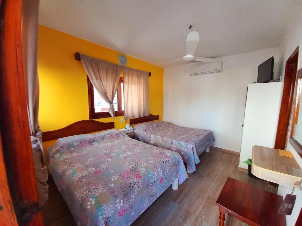 特科卢特拉Posada Casa Bugambilias的黄色墙壁客房的两张床