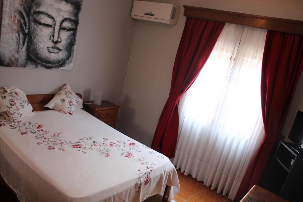 波瓦迪拉尼奥苏阿巴餐厅旅馆的一间卧室配有床和红色窗帘的窗户