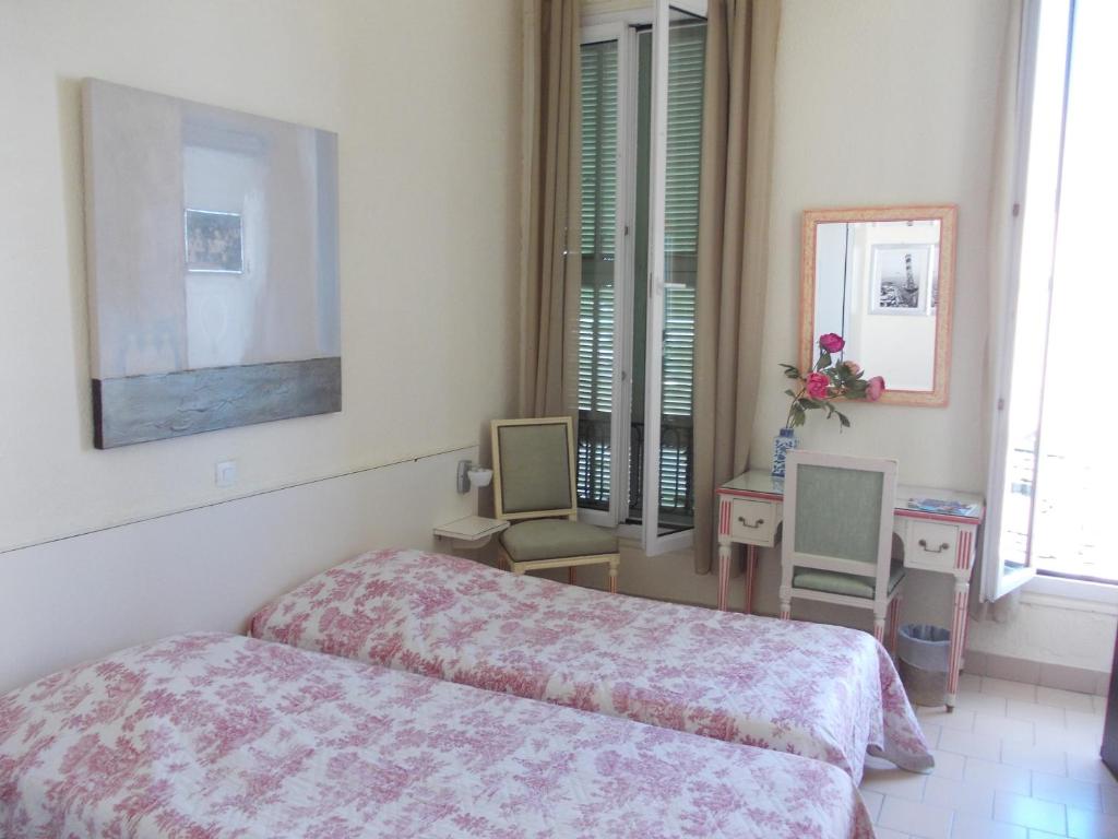 费拉角圣让鲁尔辛酒店的一间卧室配有一张床和两把椅子