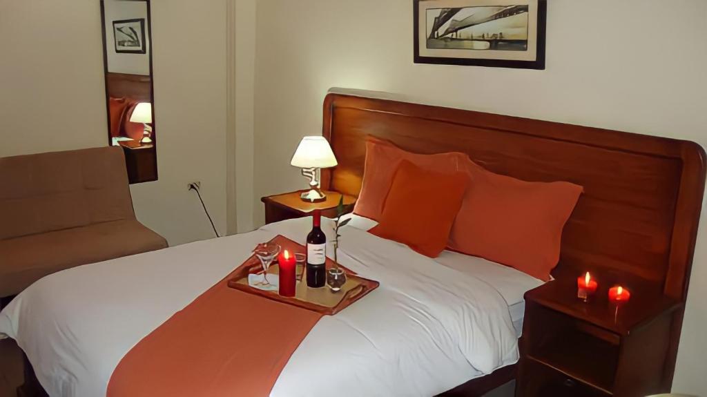 波托维耶霍Hotel Madrigal的酒店客房,配有一张带蜡烛托盘的床