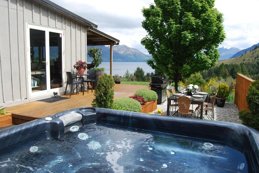 克洛斯本Private Cottage with Spa and Amazing Lake Views的房屋旁甲板上的热水浴池