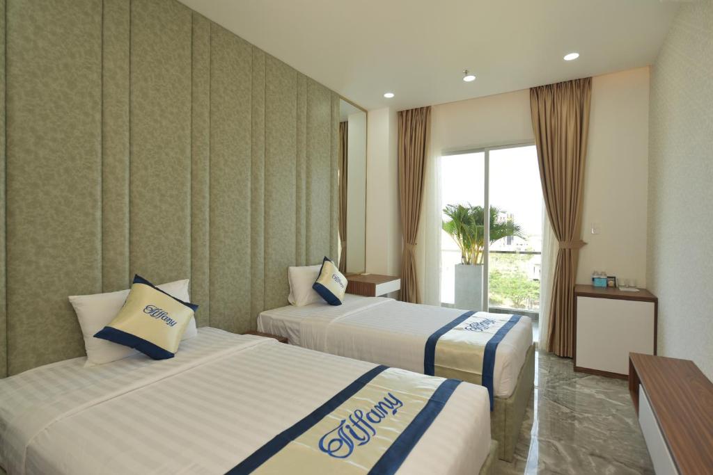 潘切TIFFANY HOTEL & RESTAURANT的酒店客房设有两张床和窗户。