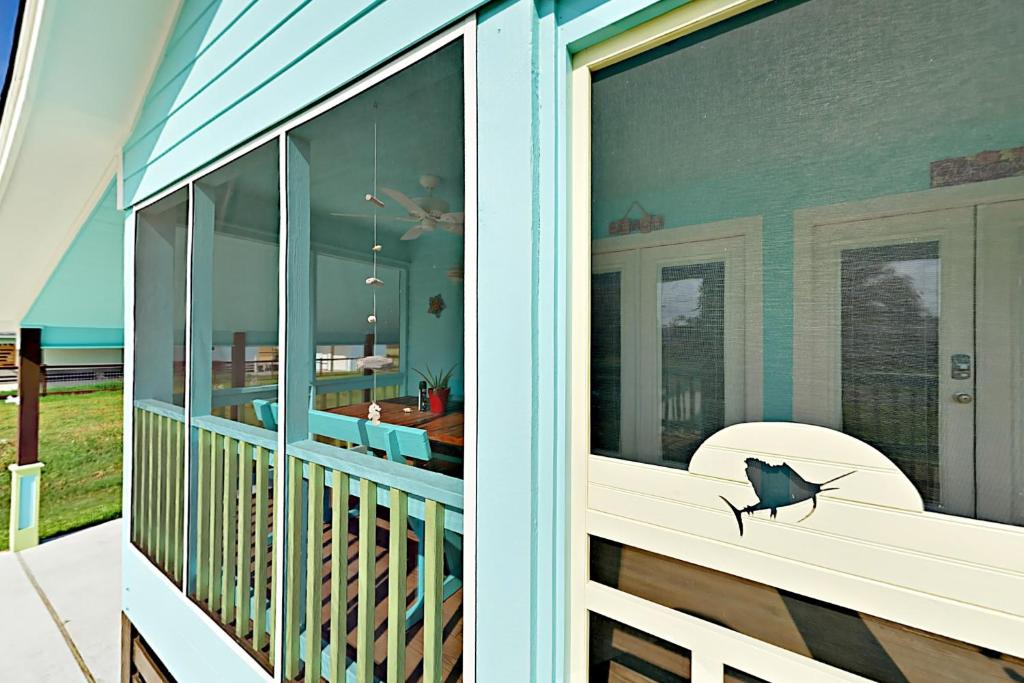 罗克波特South Pearl Sailfish的房屋设有阳台,窗户上贴有鱼贴纸
