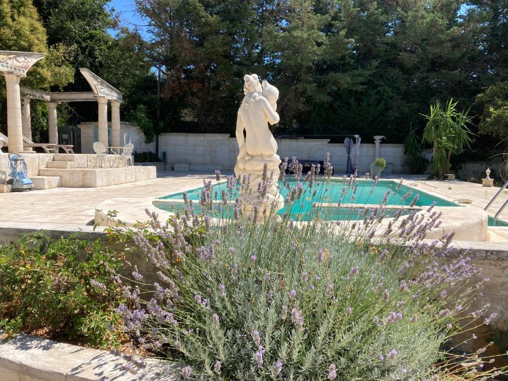 耶尔Gîte Encore Un Soir的游泳池旁花园中的雕像