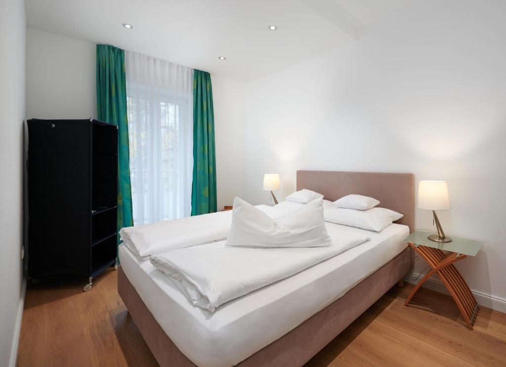 纽伦堡Deluxe Apartments Christina 120 m² im Design Hotel Vosteen的卧室配有带绿色窗帘的大型白色床