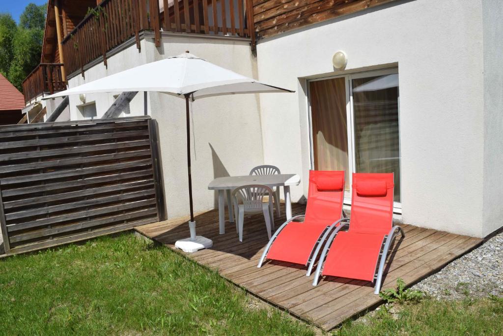 昂塞勒T3 coquet et lumineux aux pieds des pistes的庭院配有桌椅和遮阳伞。