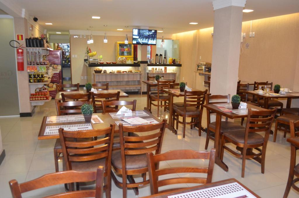 韦斯帕夏诺Hotel Grande Minas的一间摆放着木桌和椅子的餐厅
