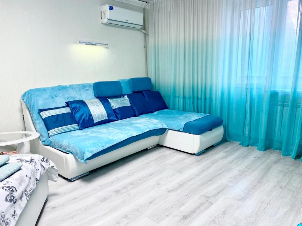 第聂伯罗Апартаменти завжди зі світлом的蓝色和白色的卧室配有床和窗帘