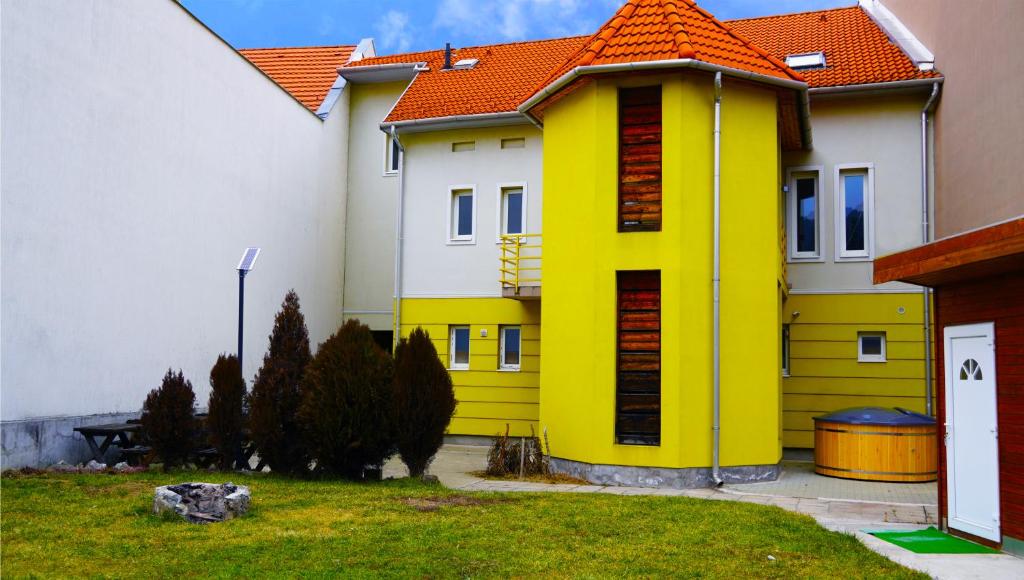 米什科尔茨Pajkos Póni Vendégház的院子里的黄色房子,有橙色屋顶