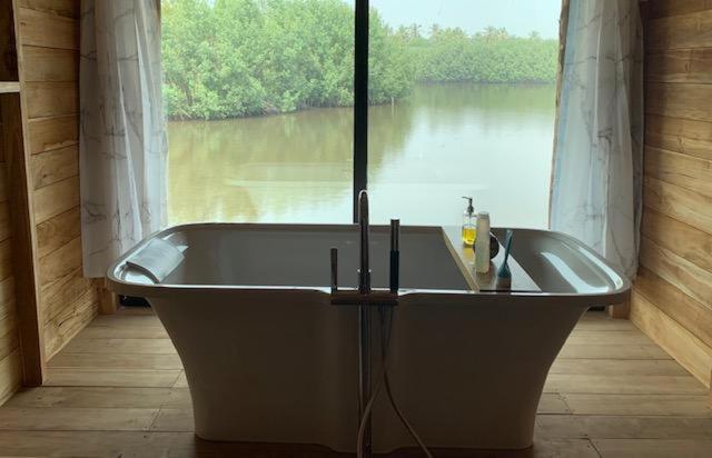 OuidahNatura Luxury Lake Hut的河景客房 - 带浴缸