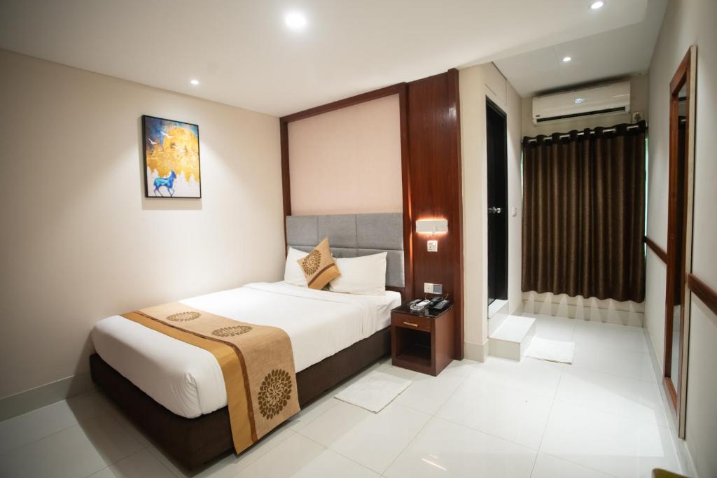 达卡Jatra Hotel Grand Royal的酒店客房设有床和窗户。