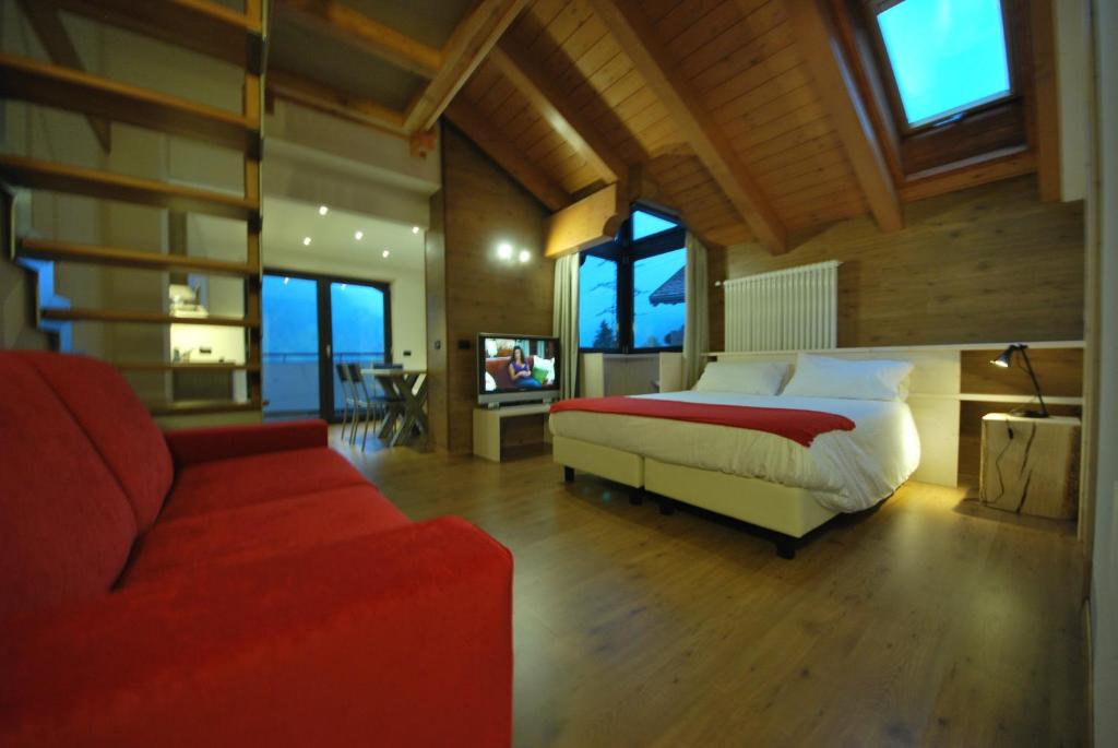 Fucine加尼扎内拉酒店的一间卧室配有一张床和一张红色的沙发