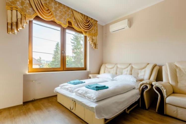 布达佩斯Deviza Apartments的一间卧室配有一张床、一张沙发和一个窗口