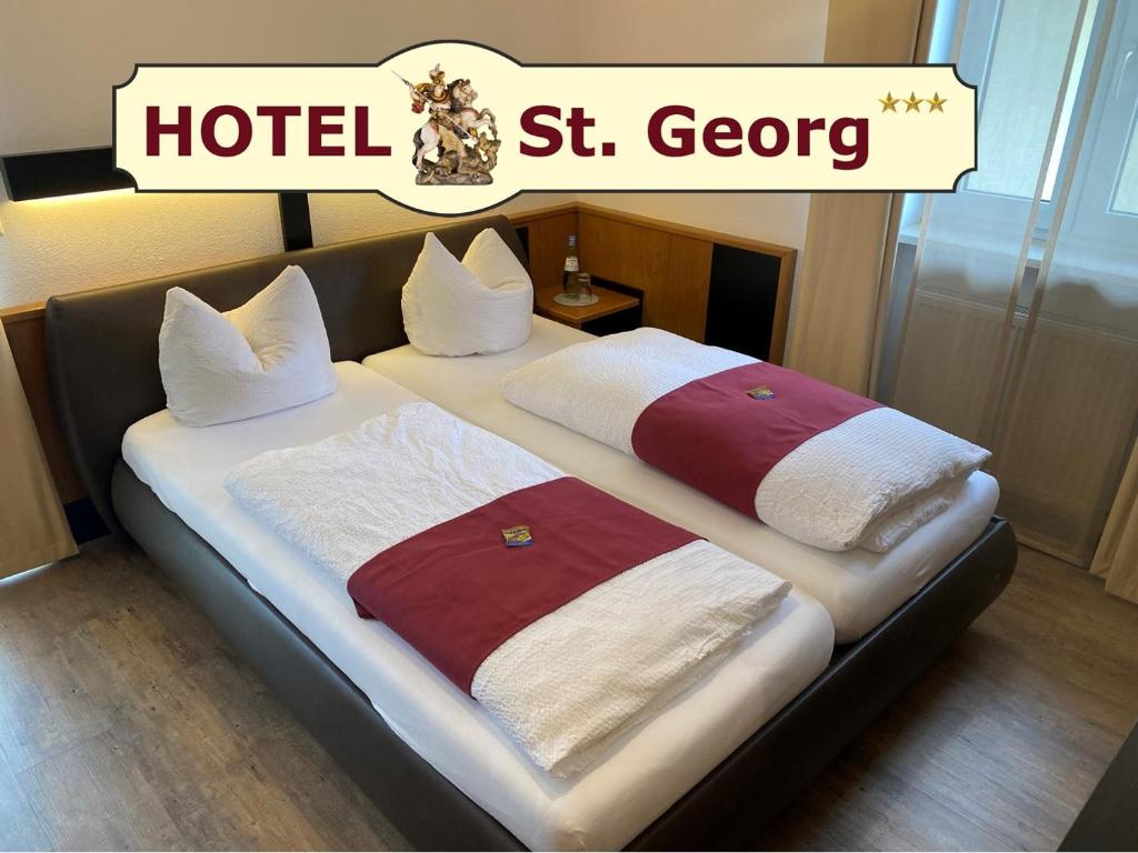圣沃尔夫冈卡尼圣乔治酒店的一张带两条毛巾的床,与酒店同床