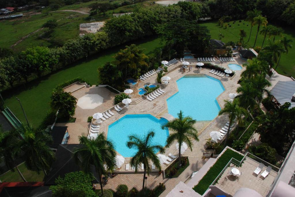 伊瓦格阿尔塔米拉星级酒店的享有带椅子和遮阳伞的游泳池的上方景致