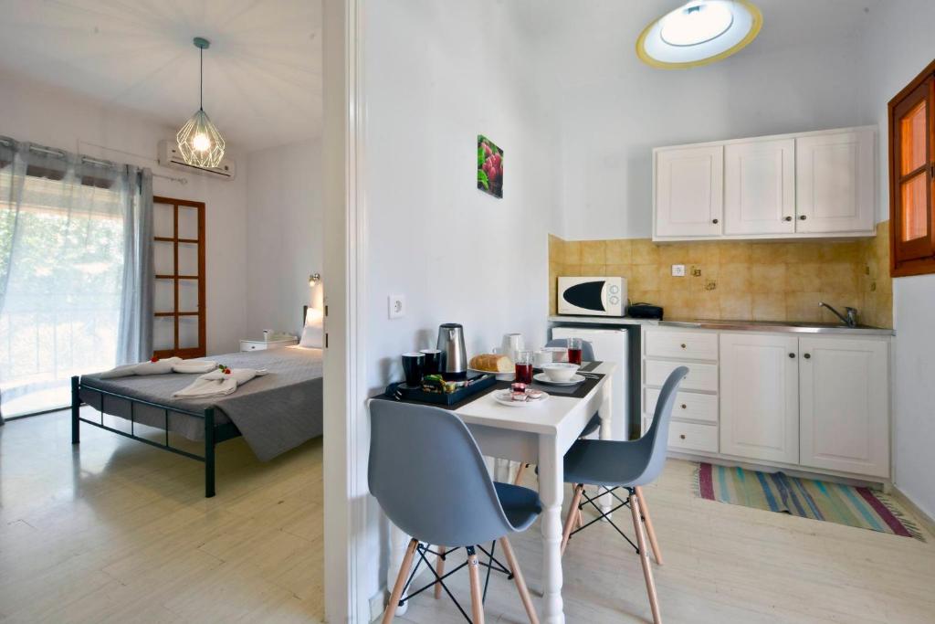 罗达Kalliopi Apartments的厨房以及带桌椅的用餐室。