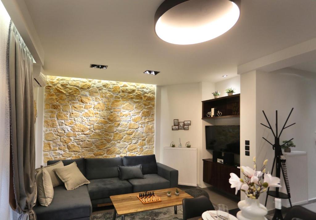 拉里萨LA Larissa Luxury Apartments Koronis的带沙发和石墙的客厅