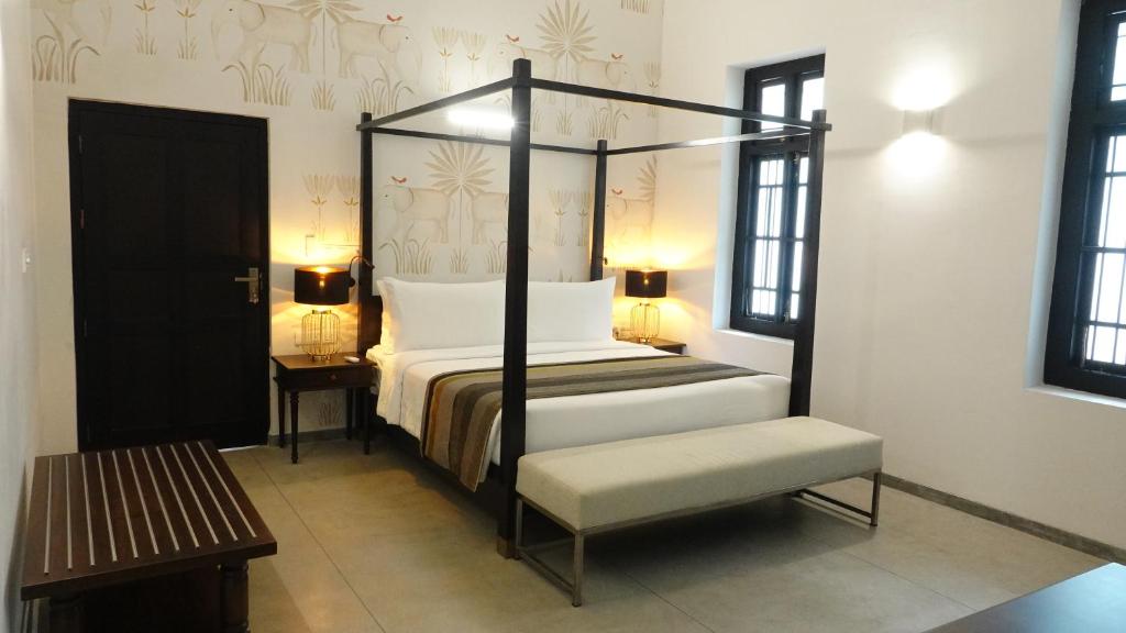 贾夫纳Jetwing Mahesa Bhawan的一间卧室配有四柱床和长凳