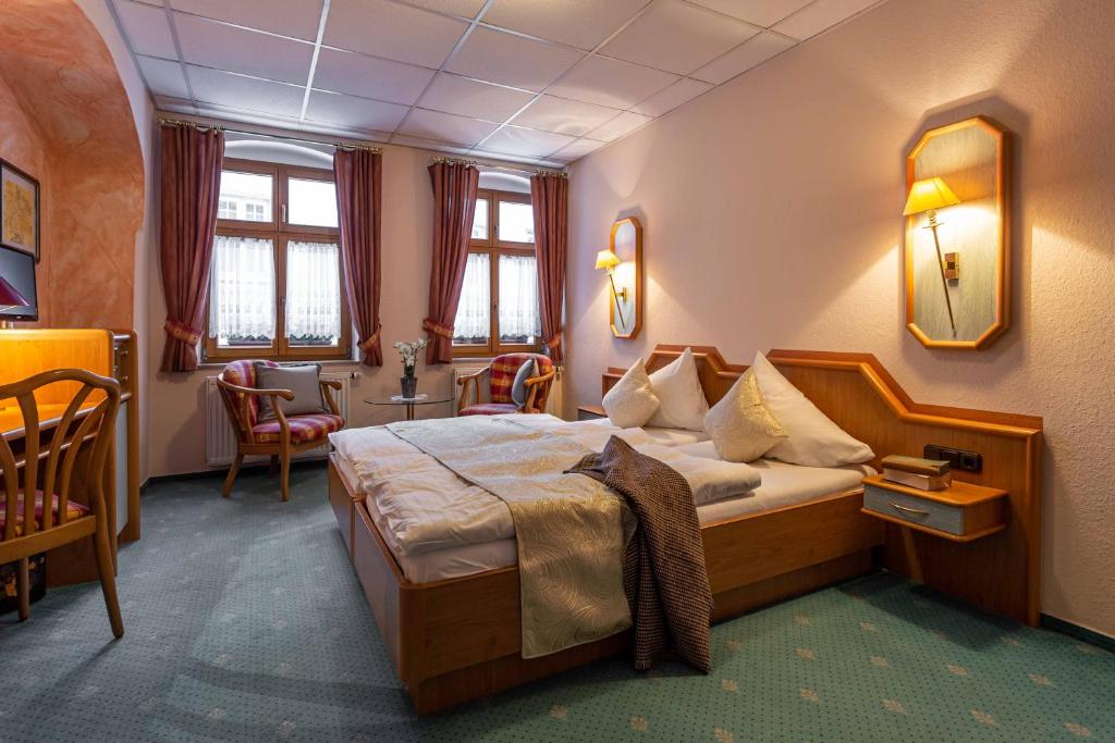 施内贝格Das Büttner的酒店客房带一张床、一张桌子和椅子