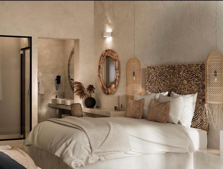 阿彻奇洛斯Delfini Beach Hotel & Suites的卧室配有一张白色大床和镜子
