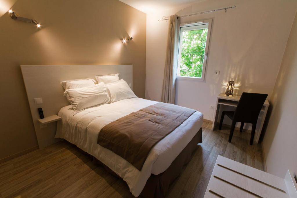 圣马丁阿尔代什莱斯佩提斯奥瑞勒斯酒店的一间卧室配有一张床、一张书桌和一个窗户。