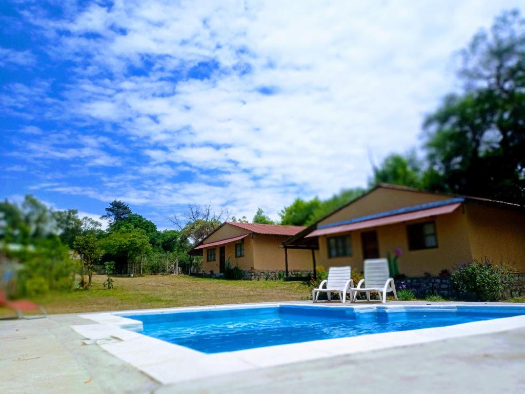 巴克罗斯Allegra casas de campo的一座带游泳池和两把椅子的房子
