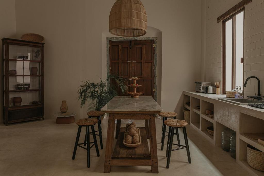 坎佩切Narrativ Lofts -Solario- Charming Historic Escape的一间厨房,里面配有一张桌子和凳子