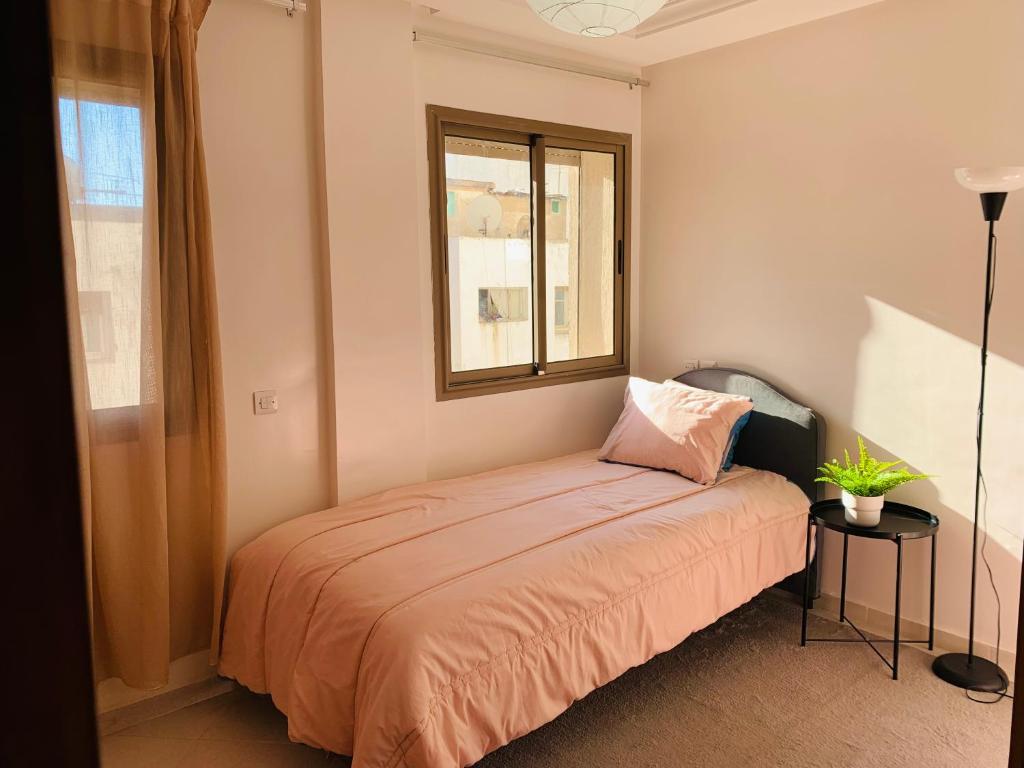 盖尼特拉Centre kenitra appartement的一间卧室设有一张床和一个窗口