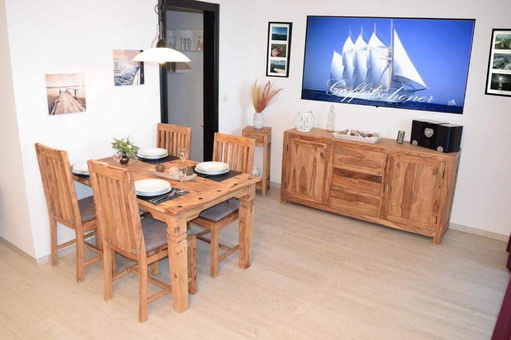 霍恩维舍多夫Ferienwohnung Gaffelschoner的一间带木桌和椅子的用餐室