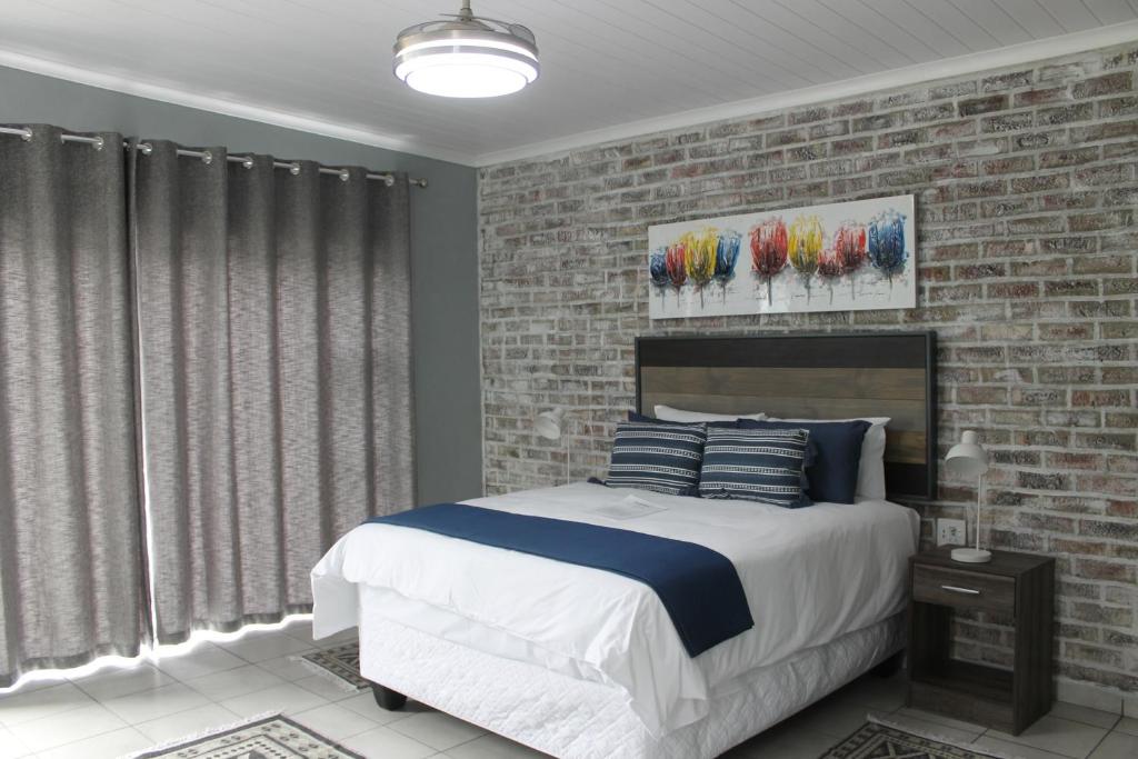 克龙斯塔德Berry Lane Guesthouse的一间卧室设有一张床和砖墙
