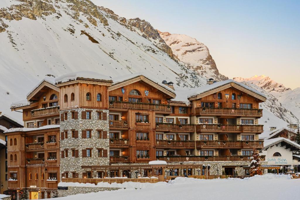 瓦勒迪泽尔Airelles Val d'Isère的一座大建筑,位于雪覆盖的山前