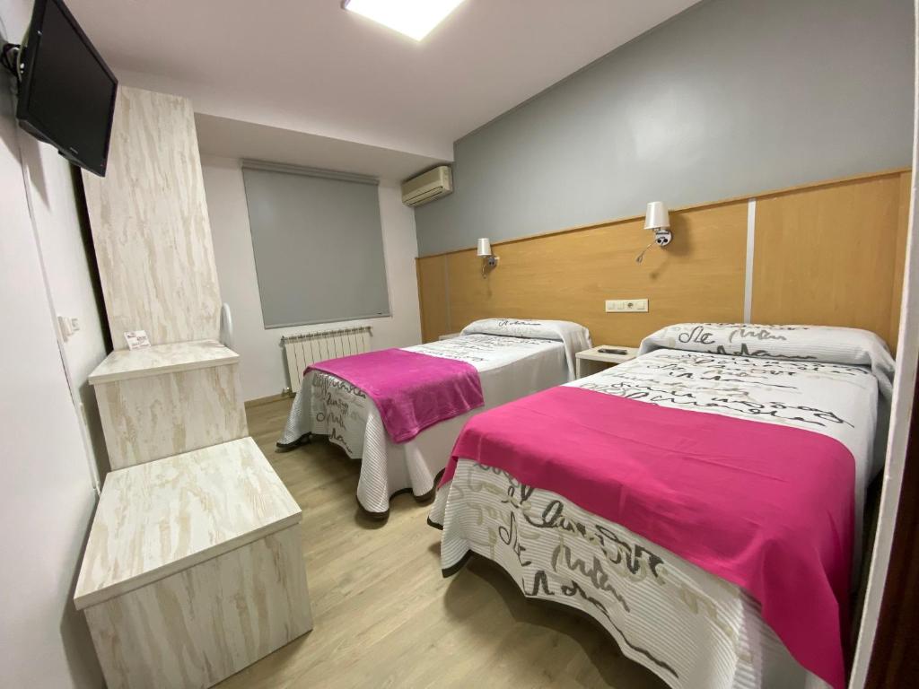 米格尔图拉圣胡安酒店的一间医院房间,配有两张带粉红色床单的床