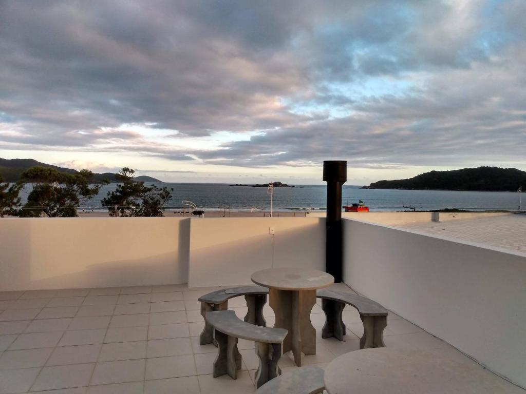 帕罗卡Apartamento Ilhas Moleques do Sul的海滩阳台的一张桌子和两把椅子