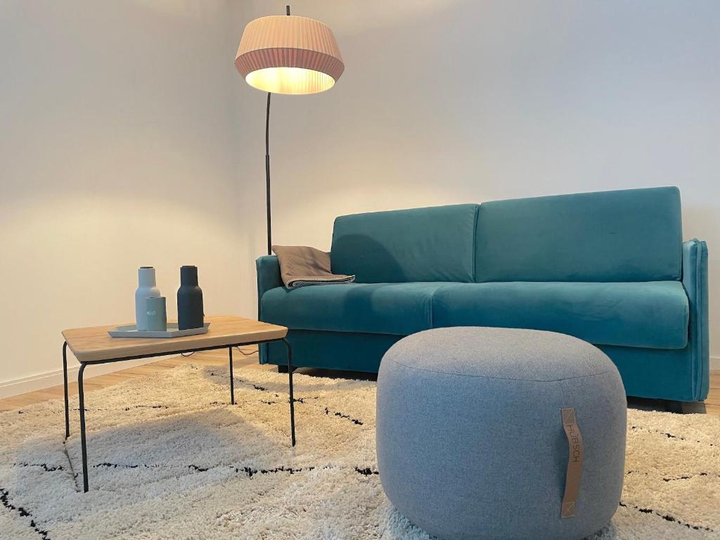 巴特维塞City Lofts Tegernsee - Moderne Studios zentral gelegen的客厅配有蓝色的沙发和桌子