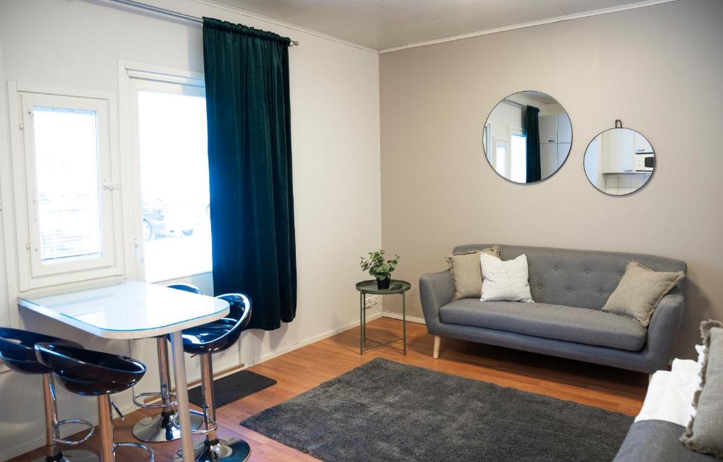 KontiolahtiMotelli Kontio的带沙发、桌子和镜子的客厅