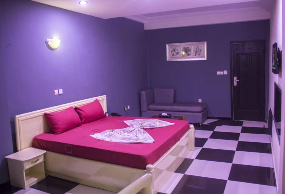 波多诺伏Mosaly Hotel PK10的紫色卧室配有一张床和 ⁇ 床