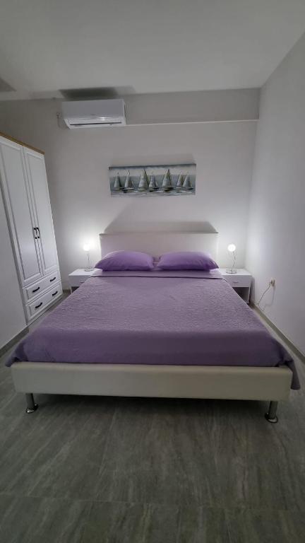 卡什泰拉Room Airport Split的一间卧室配有一张带紫色枕头的大床