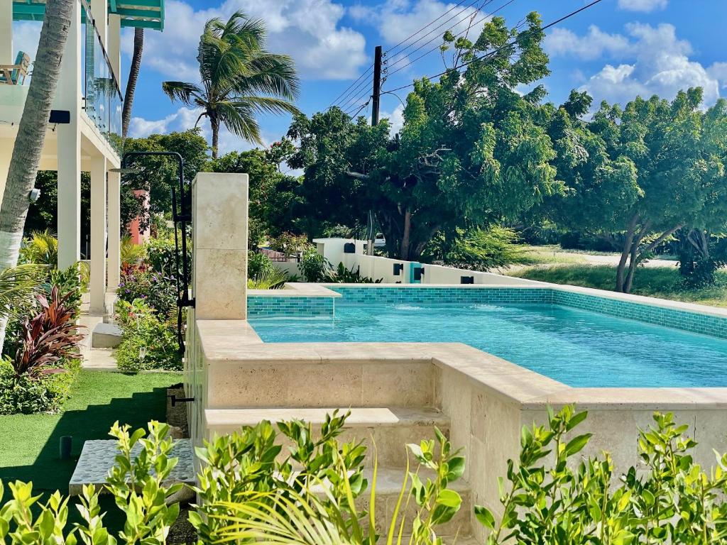 奥拉涅斯塔德Vistalmar Ocean Suites的一座树木繁茂的庭院内的游泳池