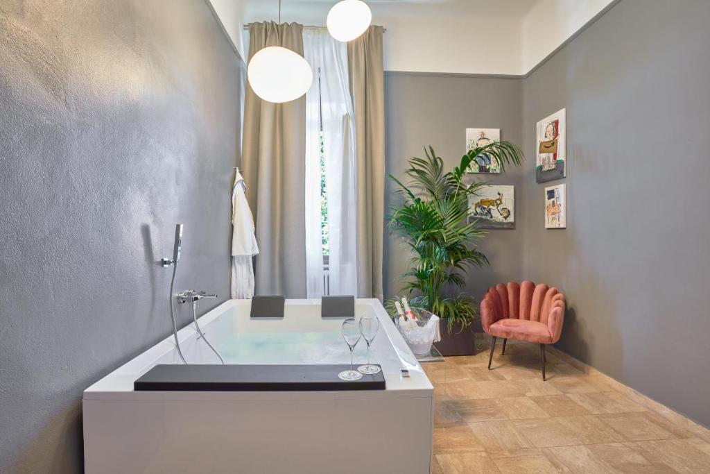比萨The Rif - Boutique Hotel的一间带椅子和植物浴缸的浴室
