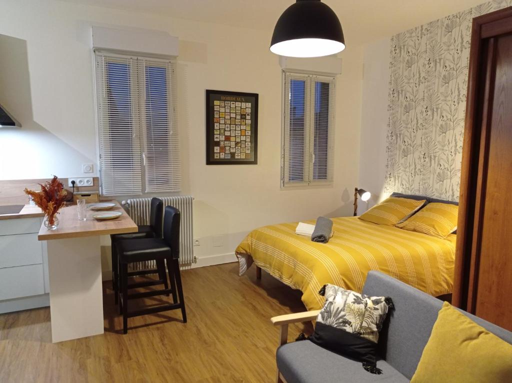 利布尔讷Le Girond'Inn的一间卧室配有一张床、一张桌子和一把椅子