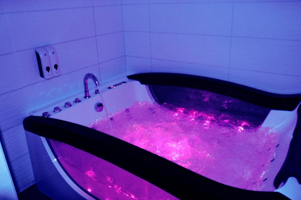 南特Chrysalide cocon的浴室内带粉红色灯的紫色浴缸